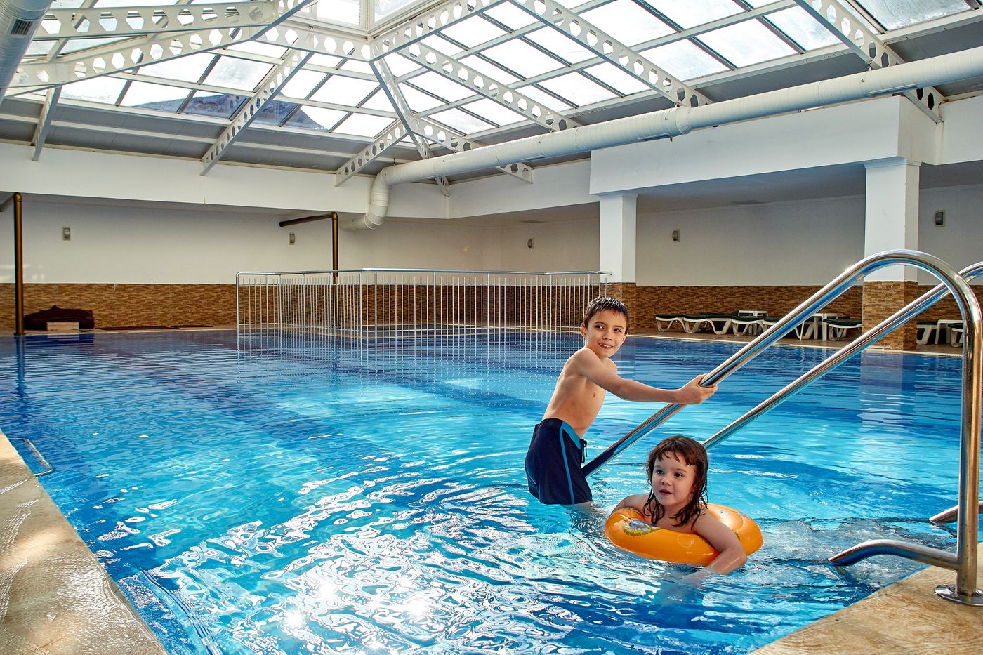 Spaßbad NRW – zwei Kinder mit Schwimmring im Becken eines Hallenbads