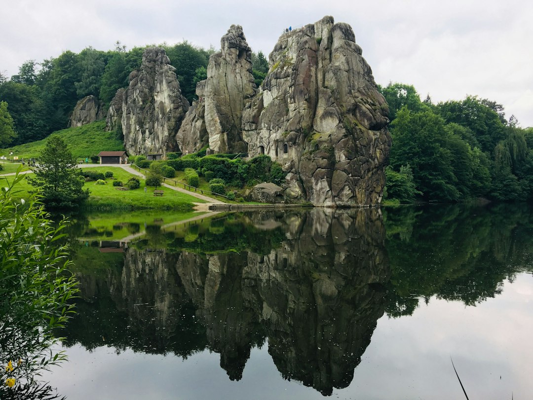 Teutoburger Wald Sehenswürdigkeiten – die Externsteine spiegeln sich im Wasser vor den Felsen