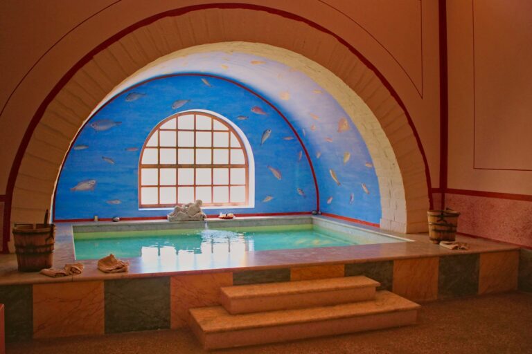 Therme NRW – Warmwasserbecken unter einem blau bemalten Rundbogen in einem römisch gestalteten Bad