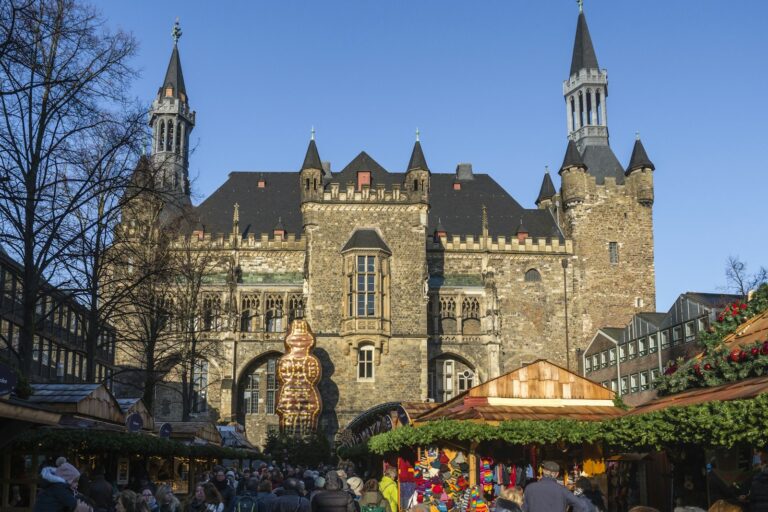 weihnachtsmarkt aachen – Buden vor dem historischen Rathaus an einem sonnigen Adventstag
