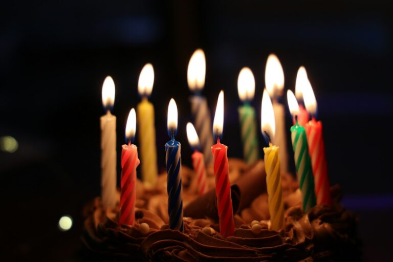 Kindergeburtstag Köln – brennende bunte Kerzen auf einem Schokoladenkuchen