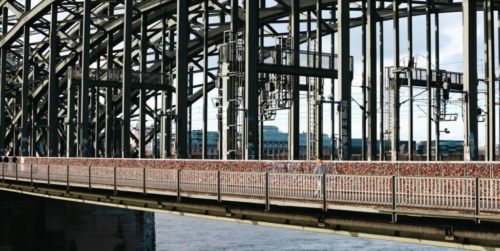 Hohenzollernbrücke in Köln mit Liebesschlössern am Geländer und Stahlbögen über dem Rhein