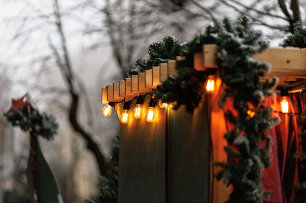 Mittelaltermarkt NRW im Advent – Holzbude mit Tannengrün und Lichterkette als Symbolbild