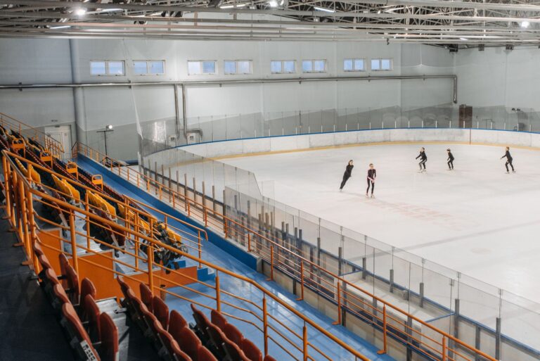 Schlittschuhlaufen Dortmund – Eishalle mit Tribüne und Läufern auf der Eisfläche