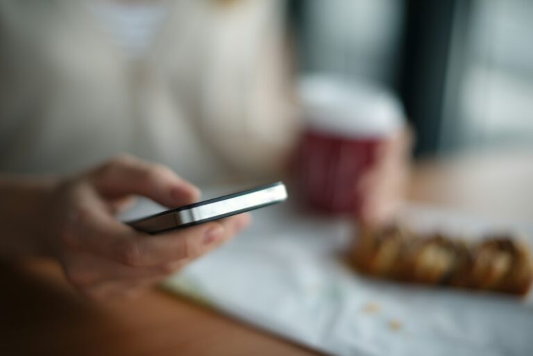 Vorwahl 0211: Düsseldorf, Schreibweisen und unbekannte Anrufe Vorwahl 0211 – Hand hält ein Smartphone am Tisch