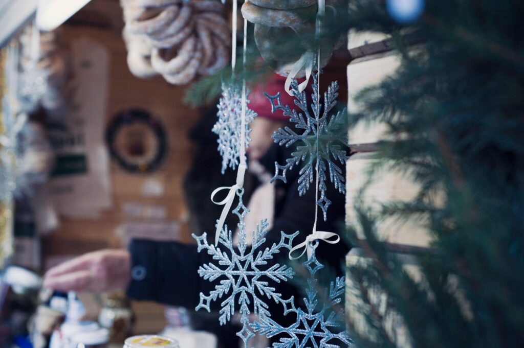 Glitzernde Schneeflocken als Weihnachtsschmuck an einer Holzbude, Symbolbild für die Buden auf dem Weihnachtsmarkt Euskirchen