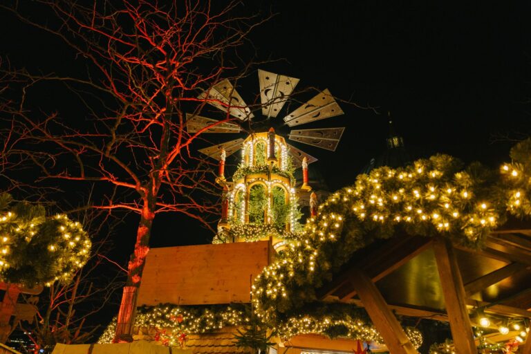 Weihnachtsmarkt Neuss – beleuchtete Weihnachtspyramide über geschmückten Marktbuden (Symbolbild)